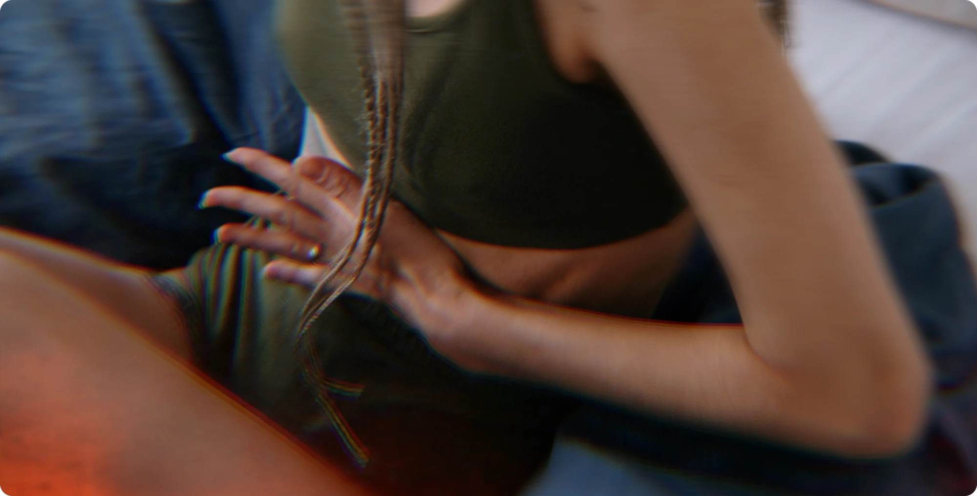 Person in green outfit sitting holding stomach